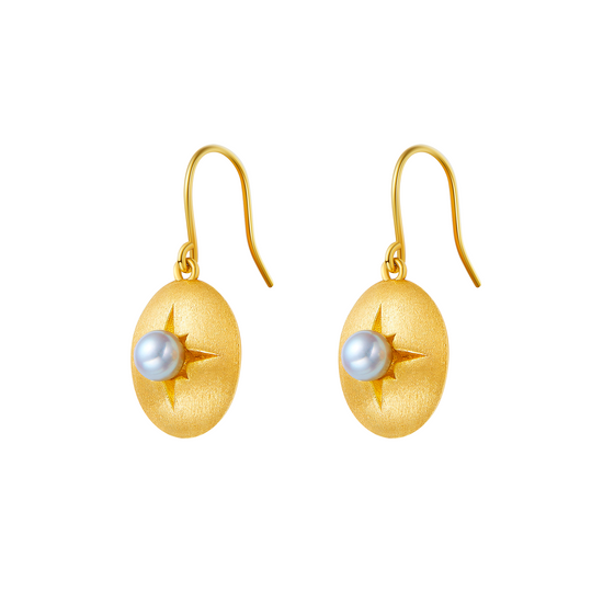 Gold earrings with pearl centers on a white background