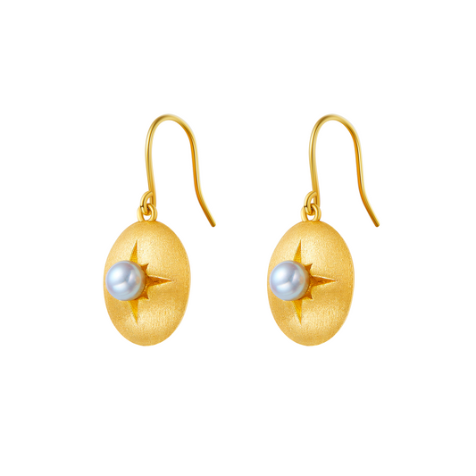 Gold earrings with pearl centers on a white background