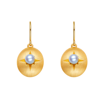 Gold earrings with pearl center on a white background