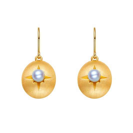 Gold earrings with pearl center on a white background