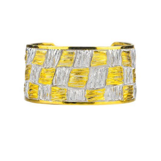 Yellow and silver woven cuff bracelet on a light gray background