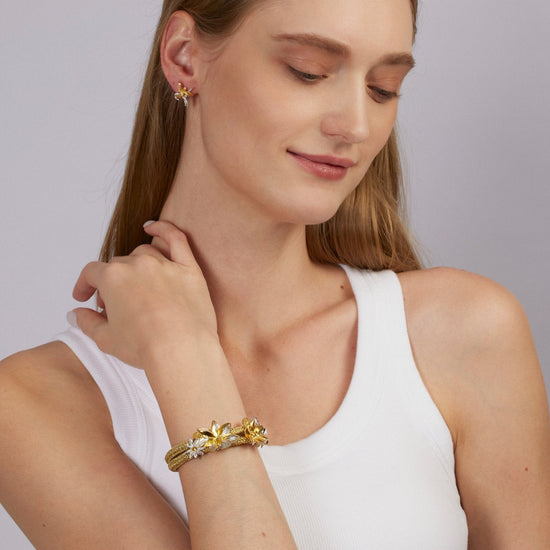 Woman wearing a gold bracelet on a plain background