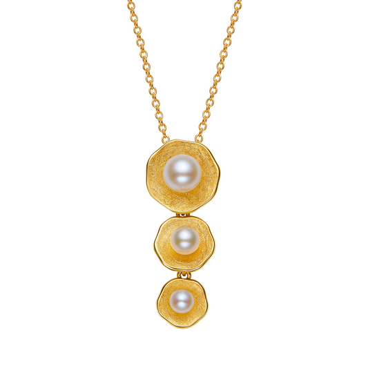 Gold necklace with three pearl pendants on a white background